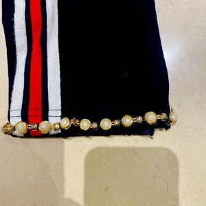 Black pants with red and white pinstripe and pearl and gold hem